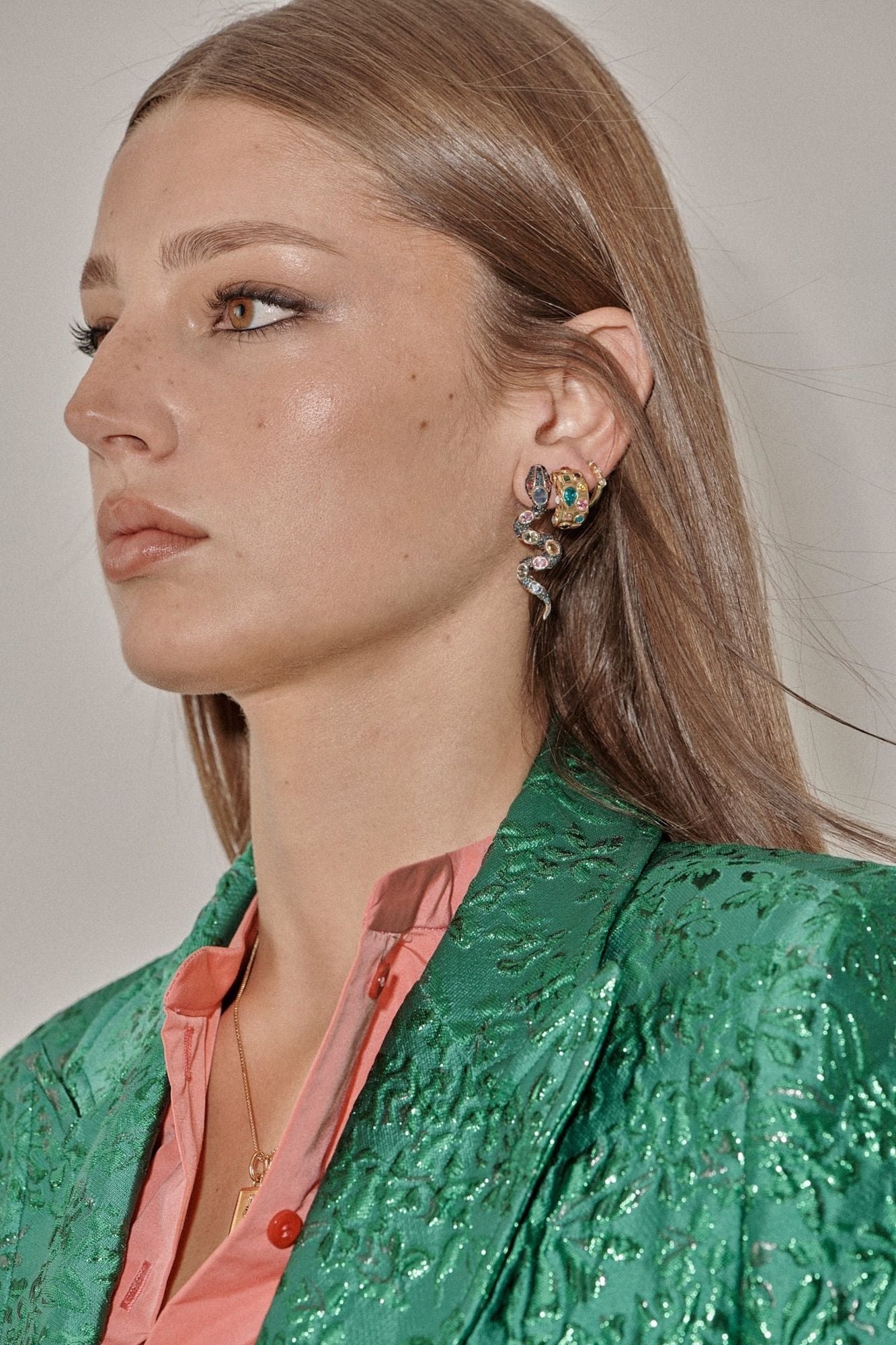 Profile in a green brocade jacket wearing a serpentine gemstone earring